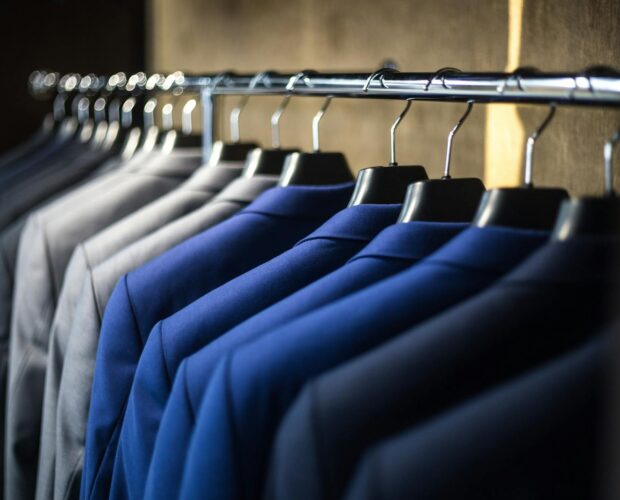Close-up of neatly arranged suits in a wardrobe, showcasing fashion and organization.